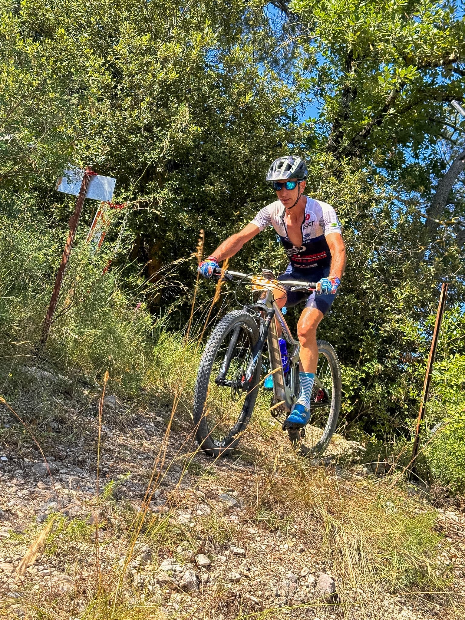 Atleta Triono in salita su un singletrack tra la vegetazione