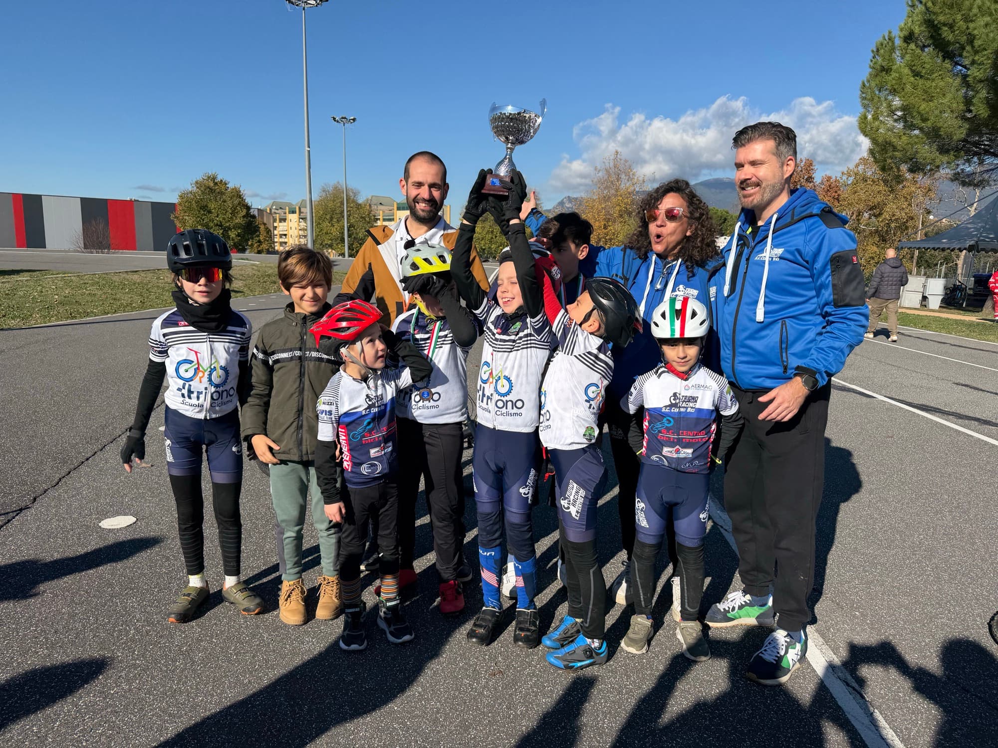 La squadra giovanile Triono festeggia con la coppa al ciclodromo, un bambino alza le braccia al cielo