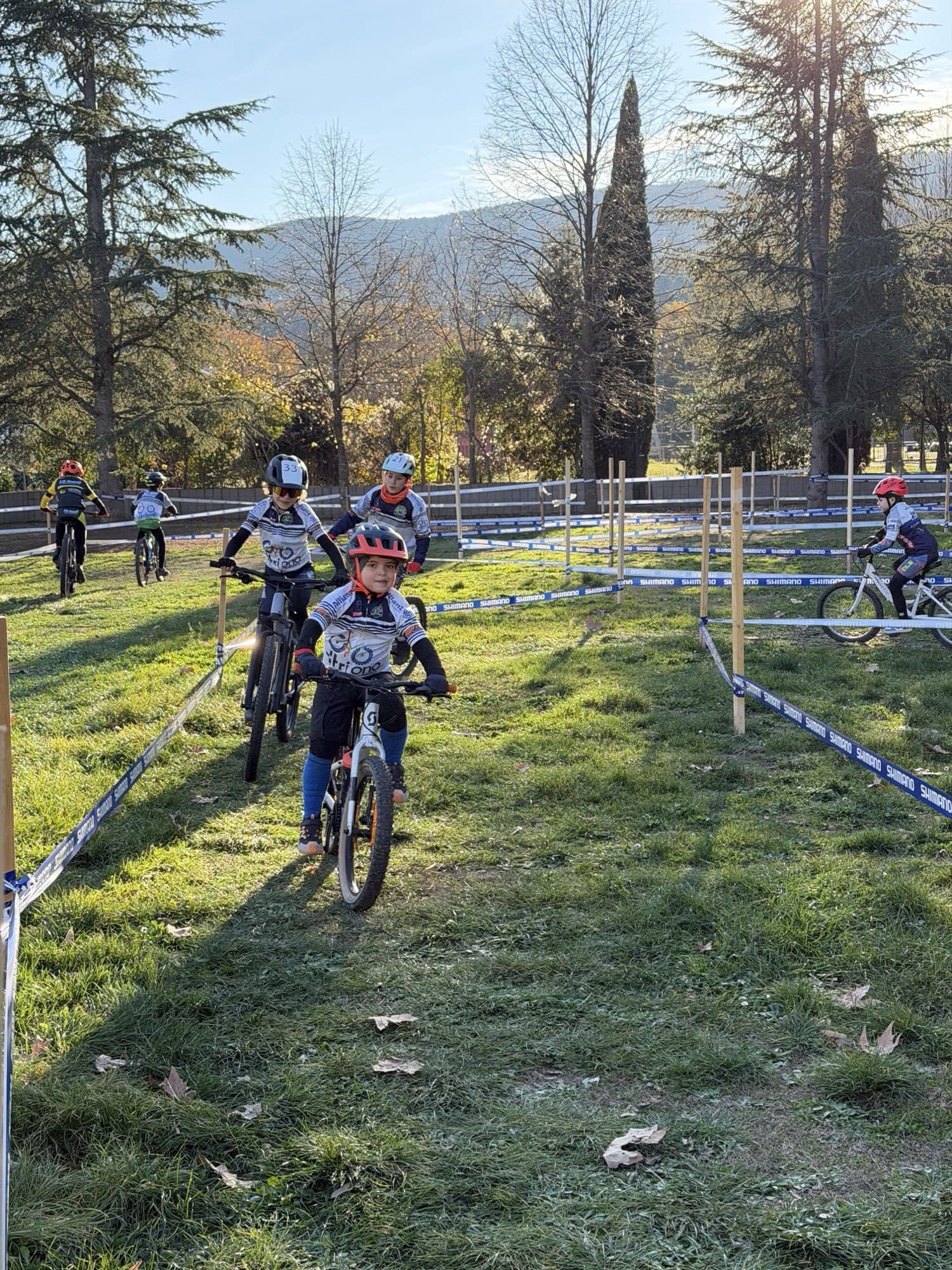 Giovani allievi Triono in mountain bike sul tracciato di cross country tra le colline, luce del mattino