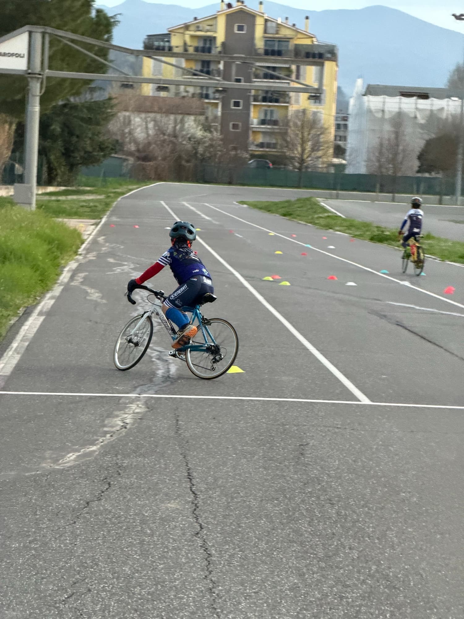 Allievo della Scuola Triono su bici da strada percorre la pista del Ciclodromo Renato Perona tra i coni