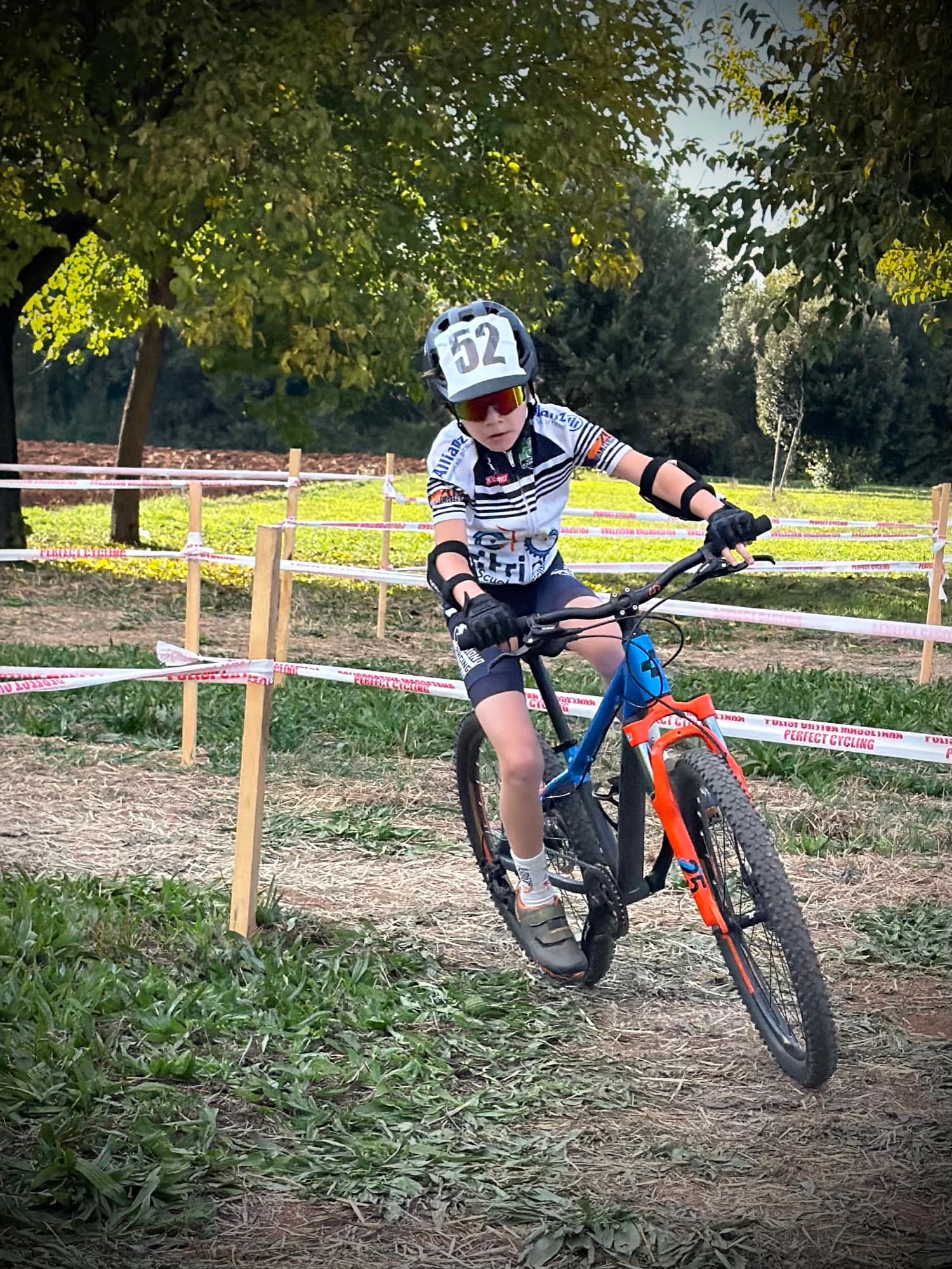 Giovane atleta Triono affronta in mountain bike il tracciato di cross country delimitato dalle transenne
