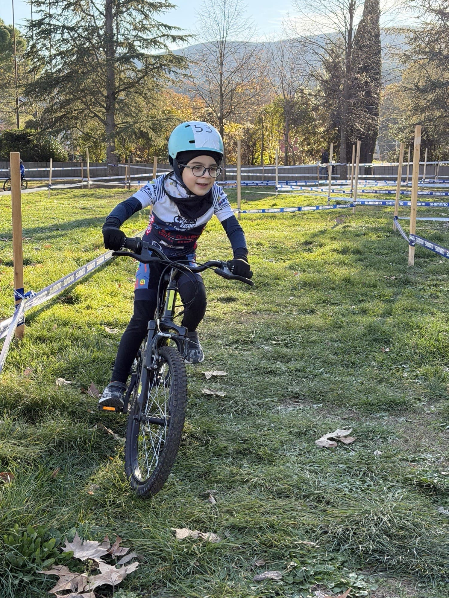 Giovane allievo sorridente in sella alla mountain bike sul percorso di gara
