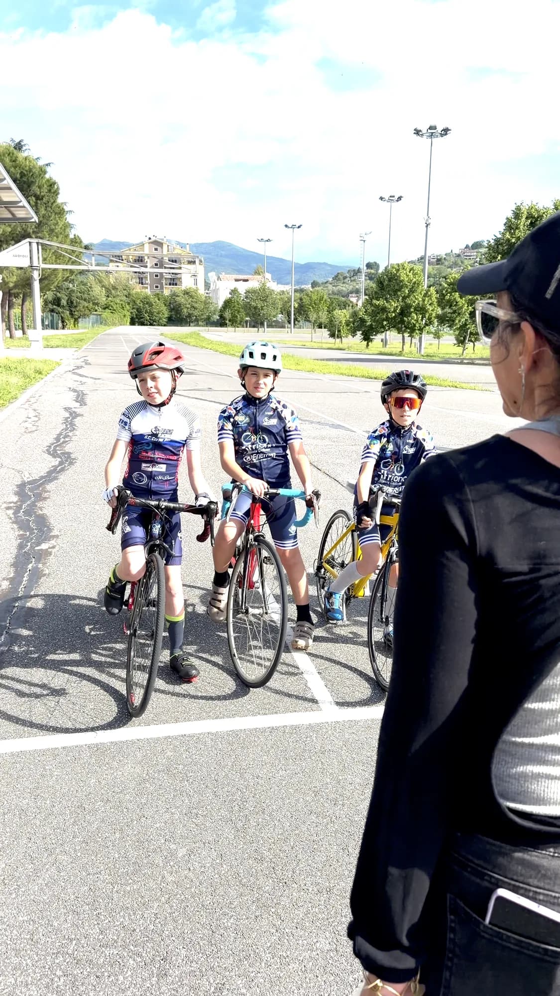 Tre allievi della Scuola Triono in sella alle bici da strada ascoltano la maestra sulla pista del ciclodromo